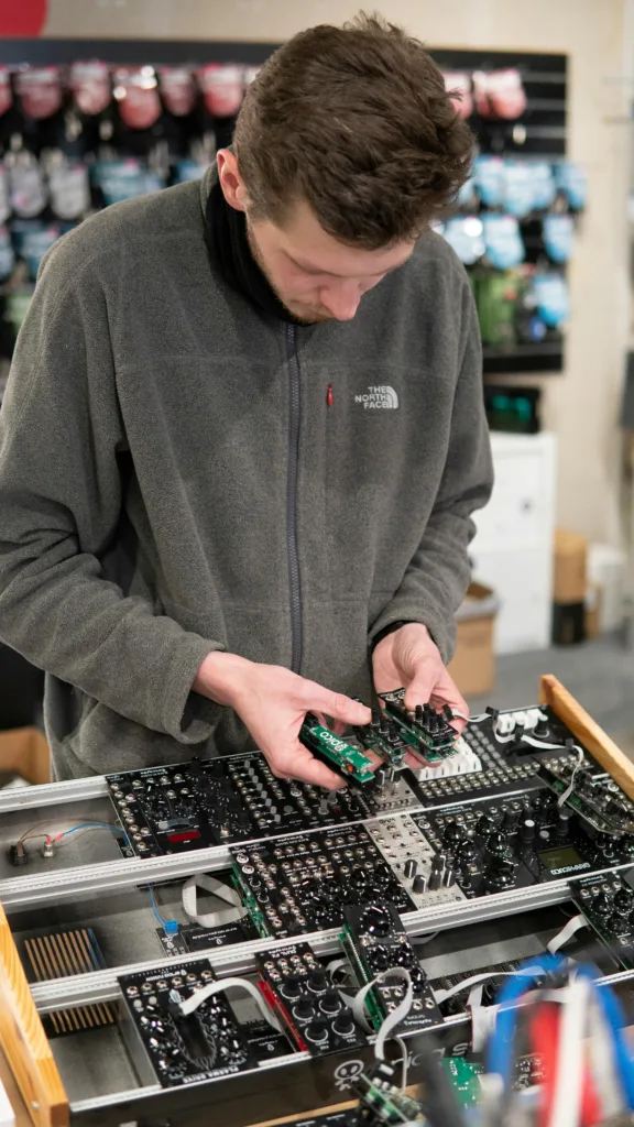 Egy férfi egy modular szintetizátort szettet állít össze